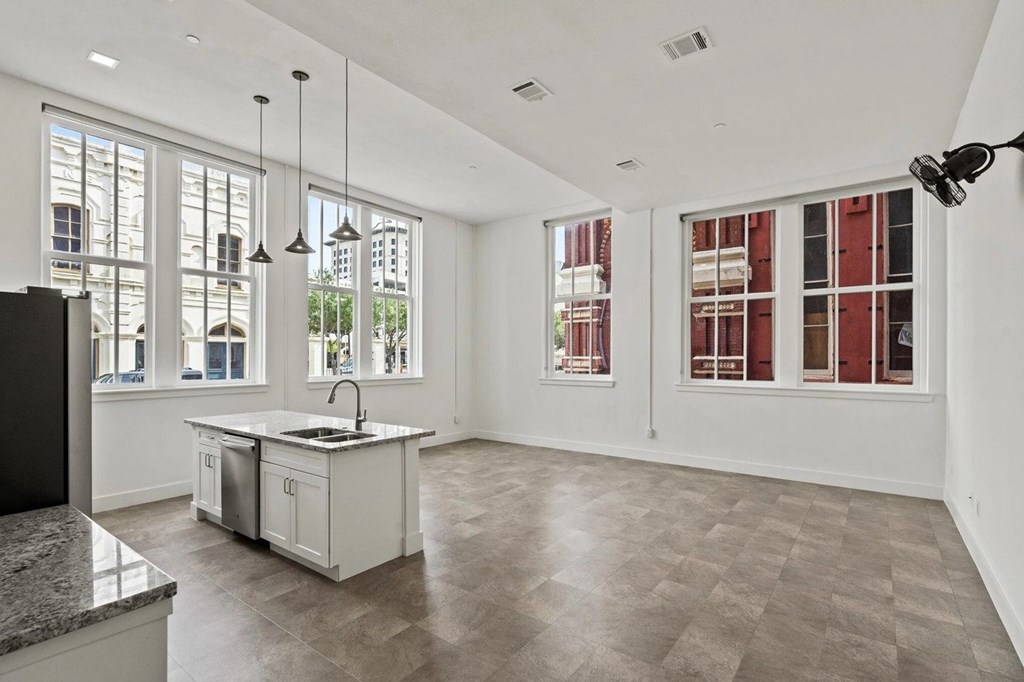 A modern kitchen with a large island and a flat screen TV.
