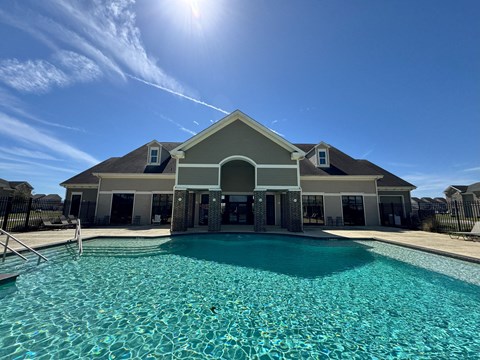 A house with a pool in front of it.