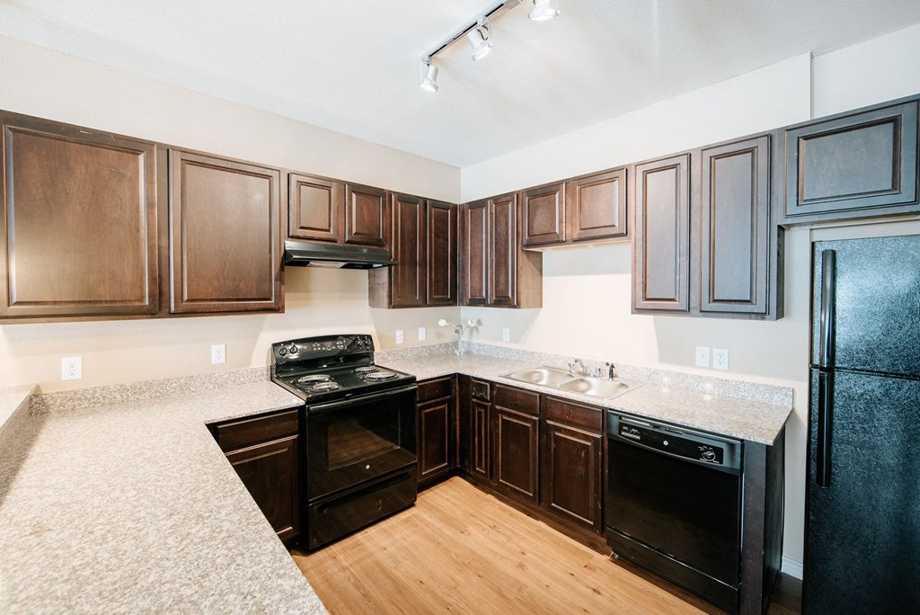 a kitchen with dark wood cabinets and white countertops