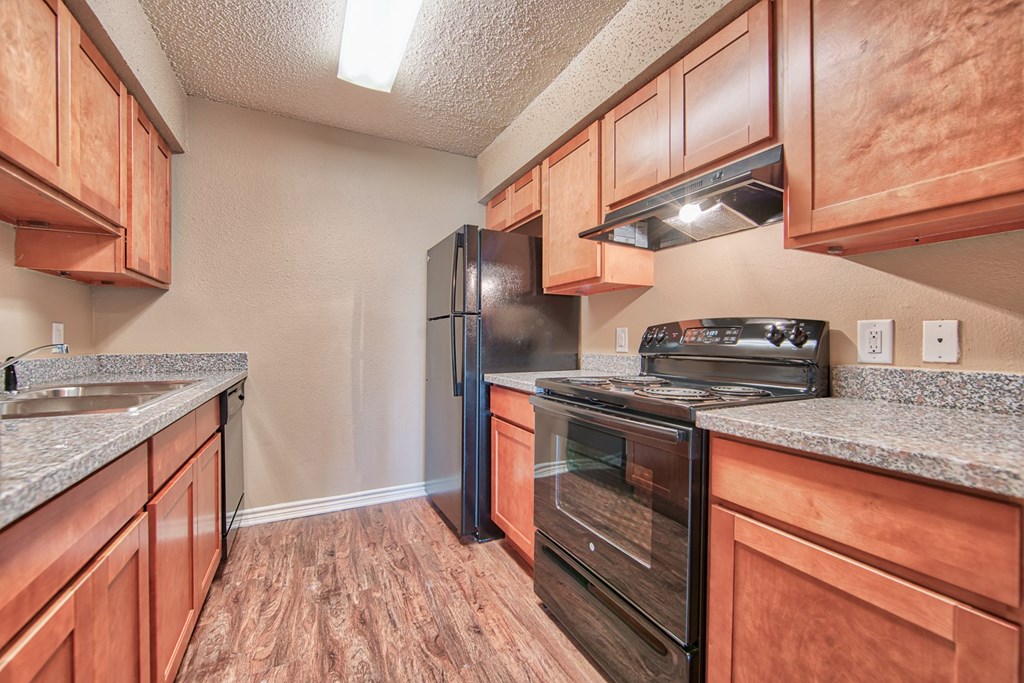 the kitchen of a home with wood cabinets and black appliances