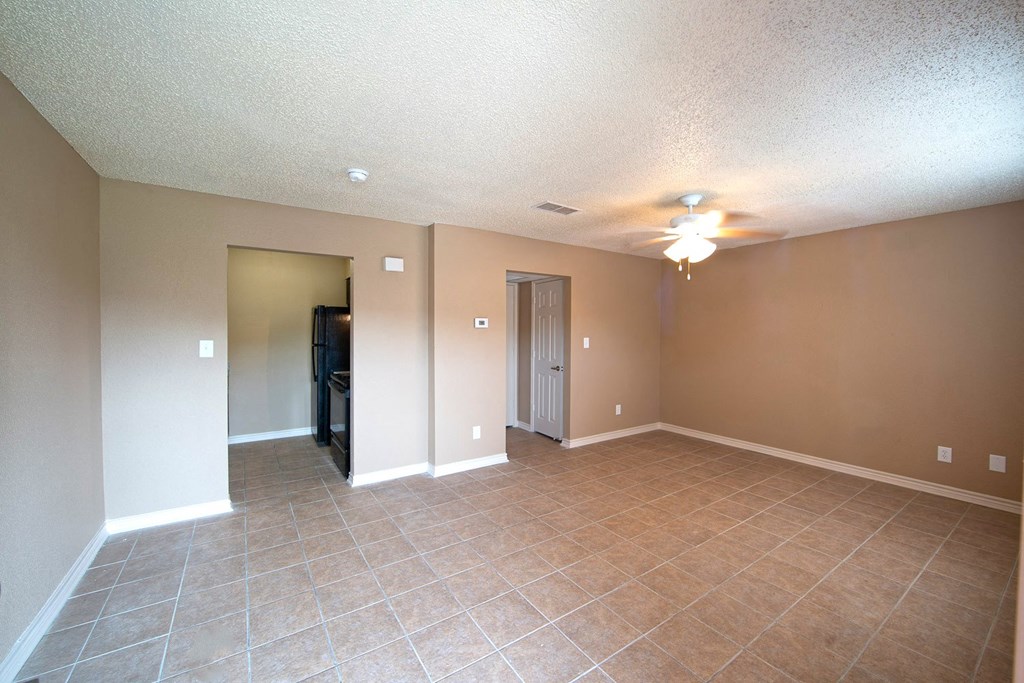 a living room with tile flooring and a ceiling fan
