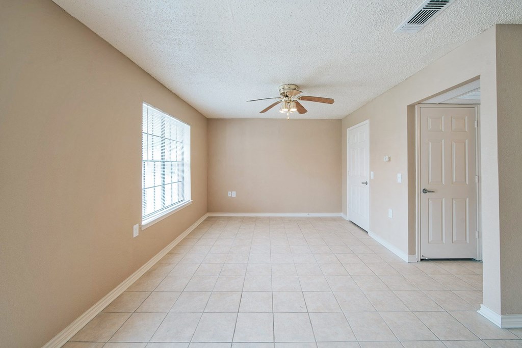 an empty dining room with a ceiling fan