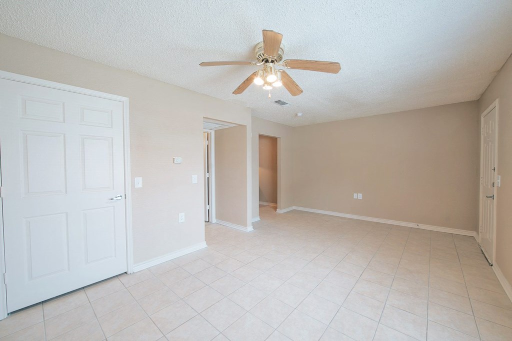 a living room with a ceiling fan and tiled floor