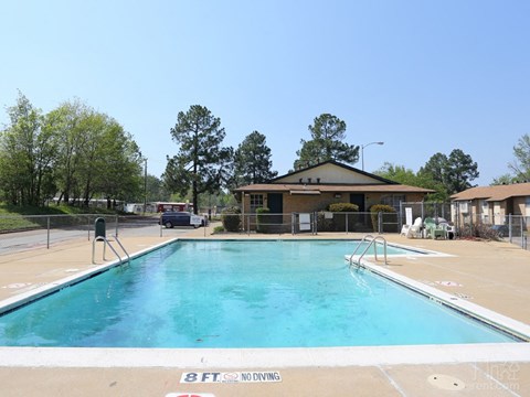 a swimming pool with a house in the background