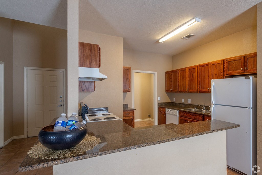 a kitchen with a granite counter top and a white refrigerator