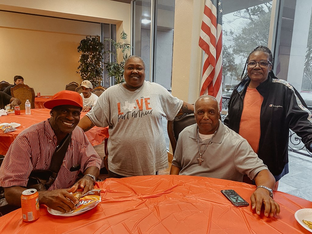 people sitting at a table with plates of food