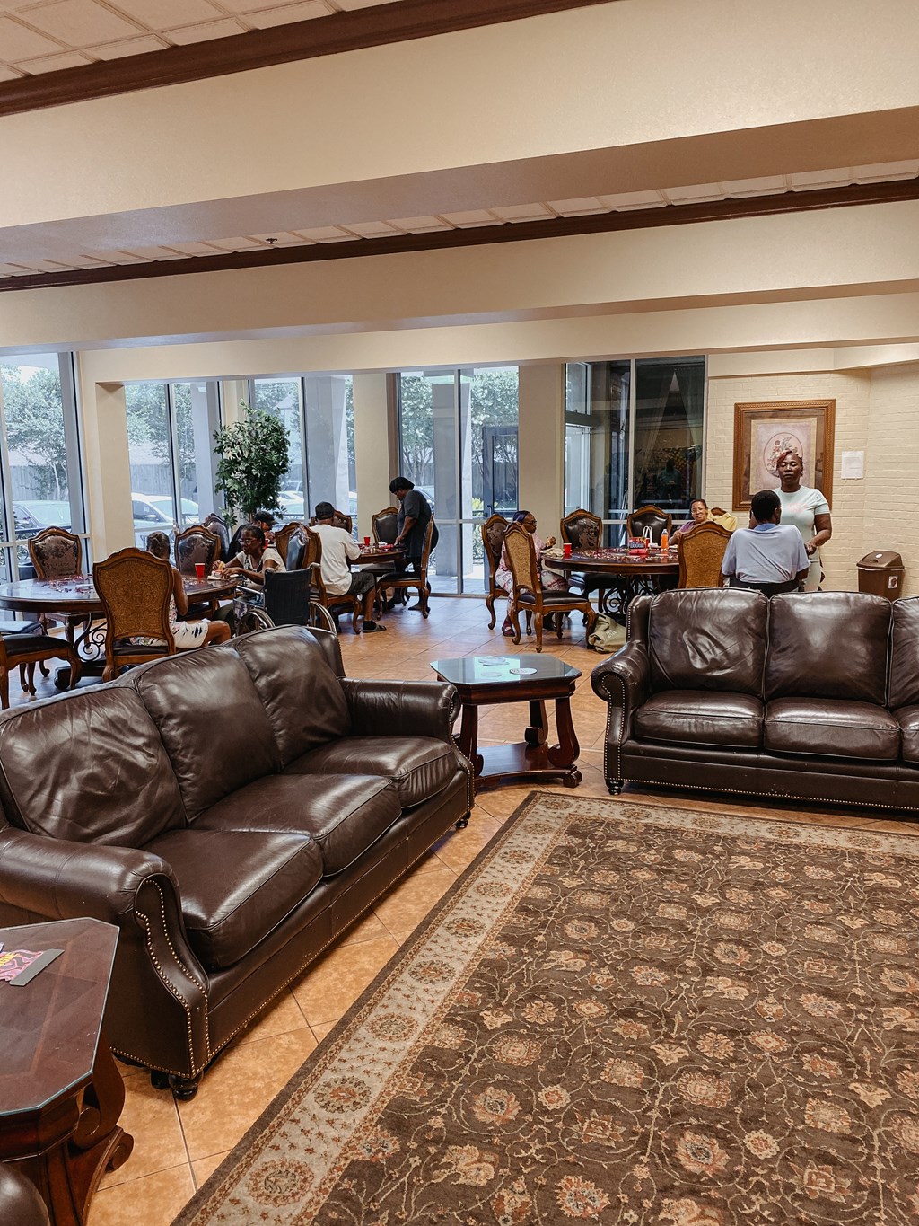 a large room with leather couches and tables and people sitting at tables in the background