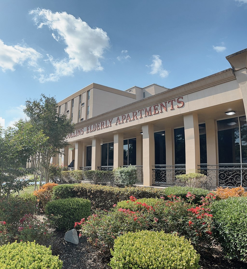 a picture of the front of the building with a garden in front of it