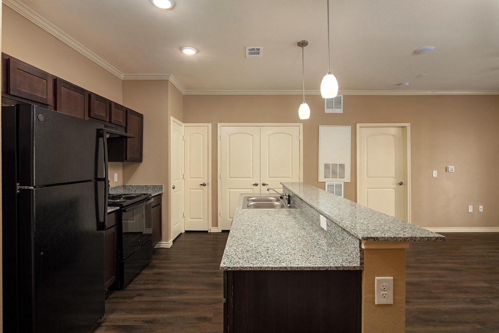 a kitchen with a granite counter top and a black refrigerator