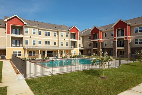 an apartment building with a pool in front of it
