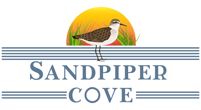 A bird is standing on a striped banner with the words "Sandpiper Cove" written underneath.