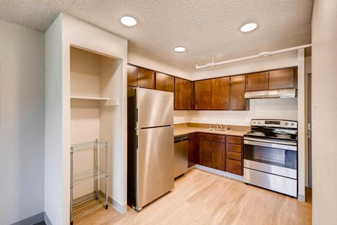 A kitchen with a refrigerator, oven, and stove.