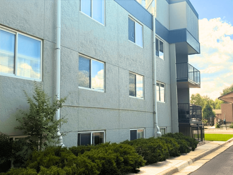 A modern apartment building with a balcony on the second floor.