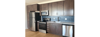 A kitchen with dark wood cabinets and stainless steel appliances.