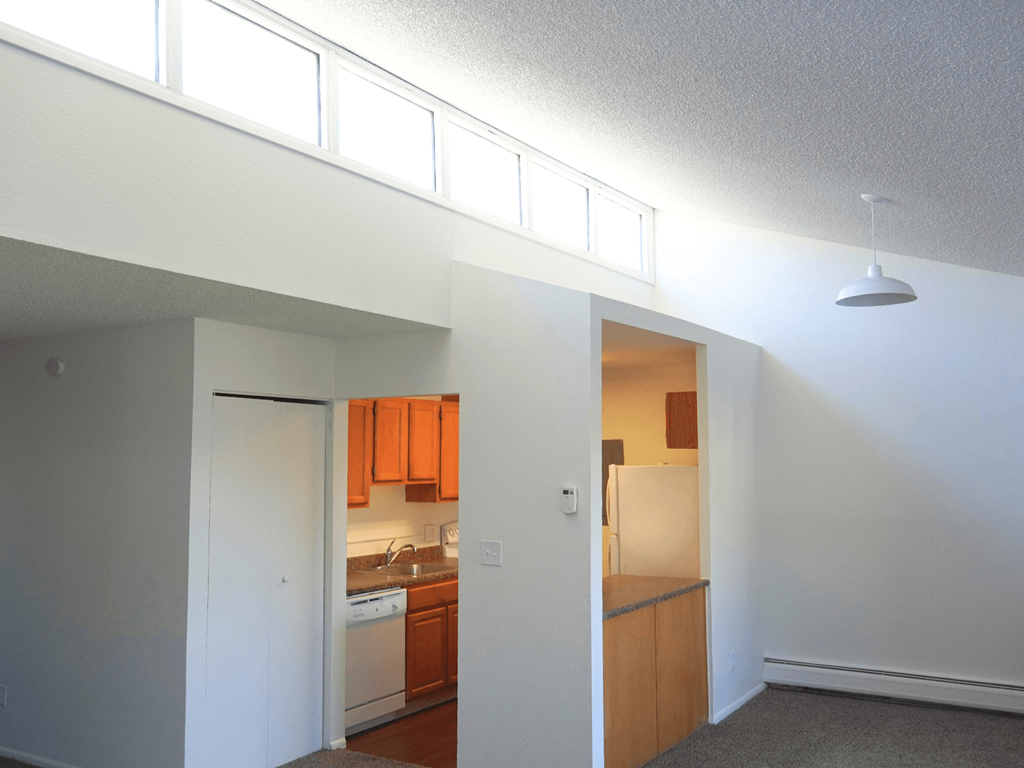 A kitchen with orange cabinets and a white refrigerator.