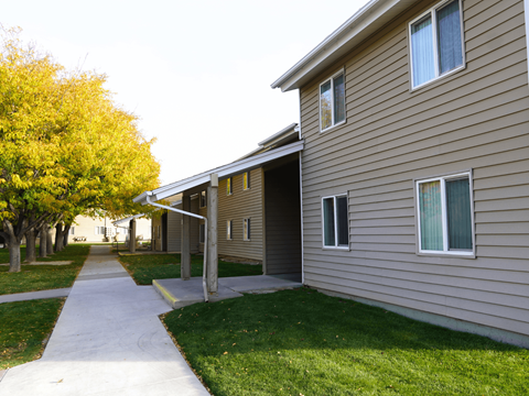 A building with a brown siding and a white door at Grand Manor Apartments, Grand Junction, CO.