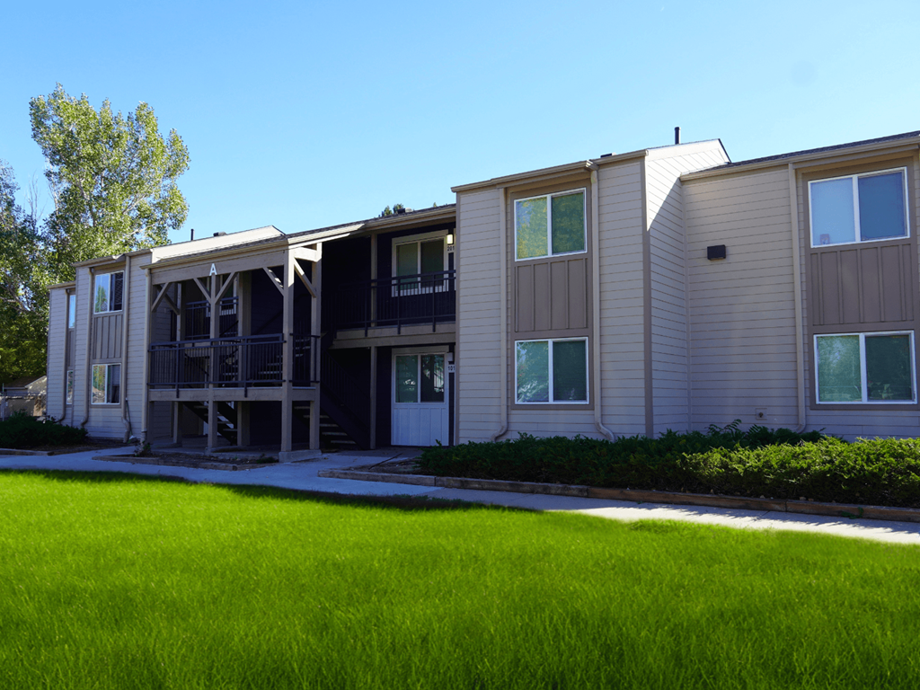 A building with a green lawn in front.