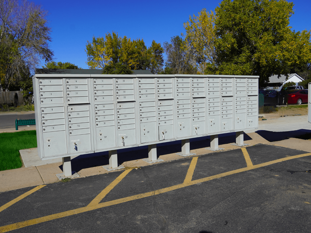 A row of mailboxes are lined up in a parking lot.