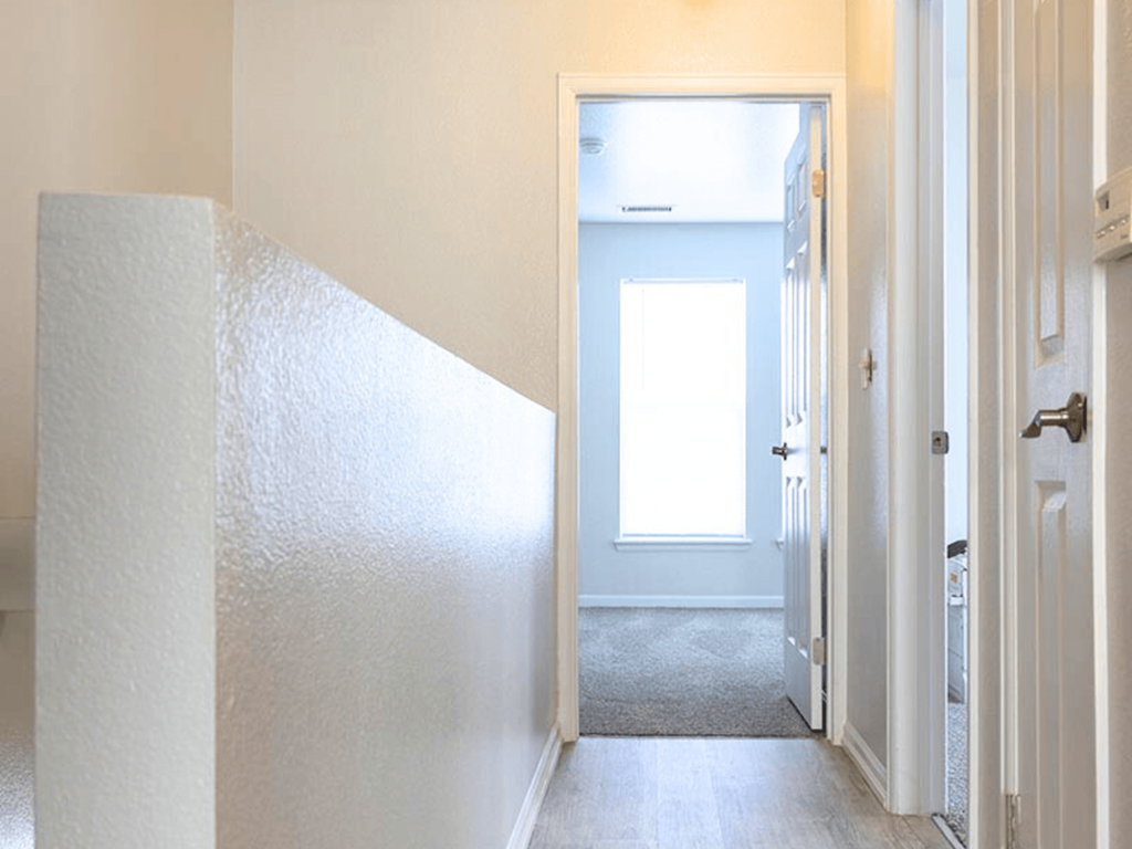 A white door is open to a hallway.