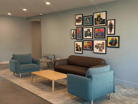A living room with a blue couch, two chairs and a coffee table.