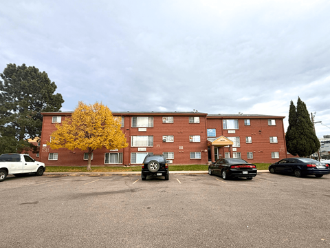 A parking lot with cars and a building in the background at Townview Plaza Apartments, Denver, Colorado.