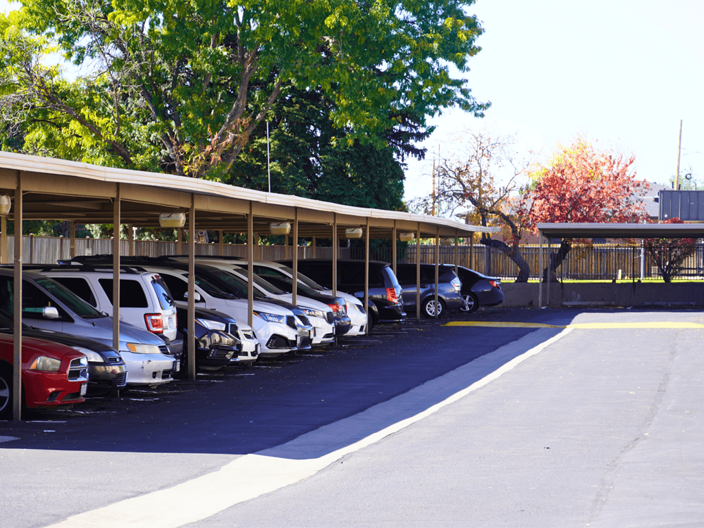A parking lot with cars parked in a row.