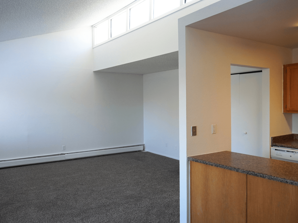 A room with a white wall and a brown cabinet.