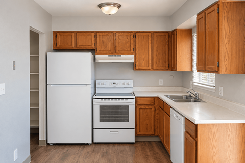 A kitchen with wooden cabinets and white appliances.