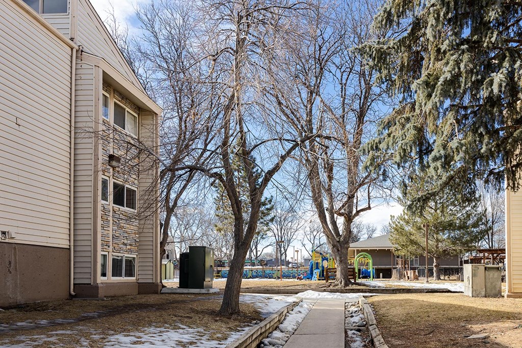 a sidewalk in front of a building with snow on the ground at Garden Court, Denver, CO
