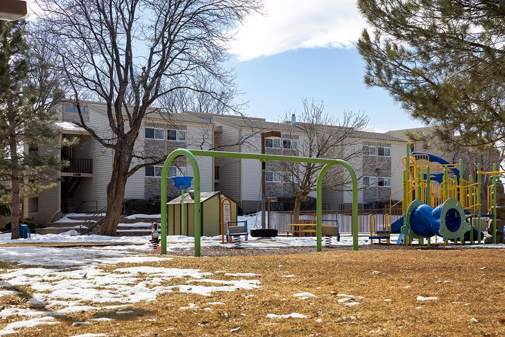 a playground with a dusting of snow in front of an apartment complex at Garden Court, Denver, Colorado, 80220