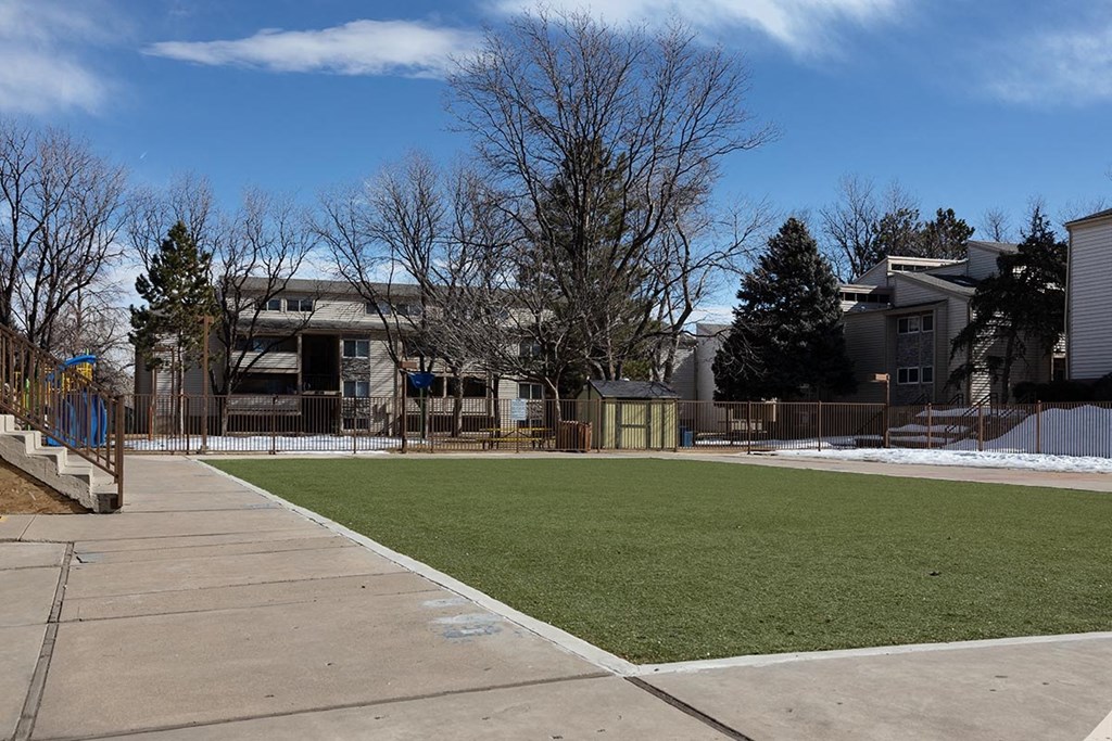 a grassy area with houses in the background at Garden Court, Denver, 80220