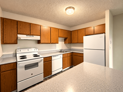 A kitchen with white appliances and wooden cabinets.