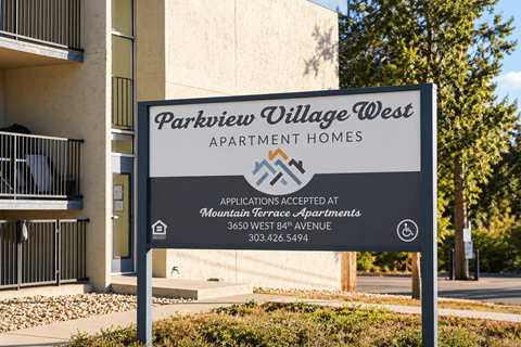 A sign for Parkview Village West Apartment Homes stands in front of a building.
