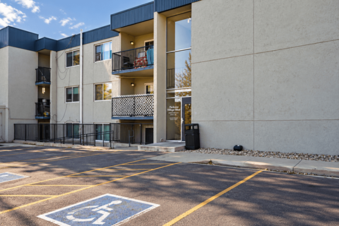 A parking lot with a handicap parking space in front of a building.