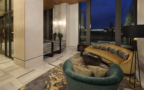 A living room with a green chair and a yellow sofa.