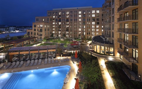 A large building with a pool in front of it.