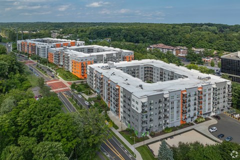 A large apartment complex with multiple buildings and a parking lot in front.