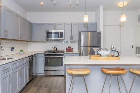 A kitchen with a stove top oven and a refrigerator.