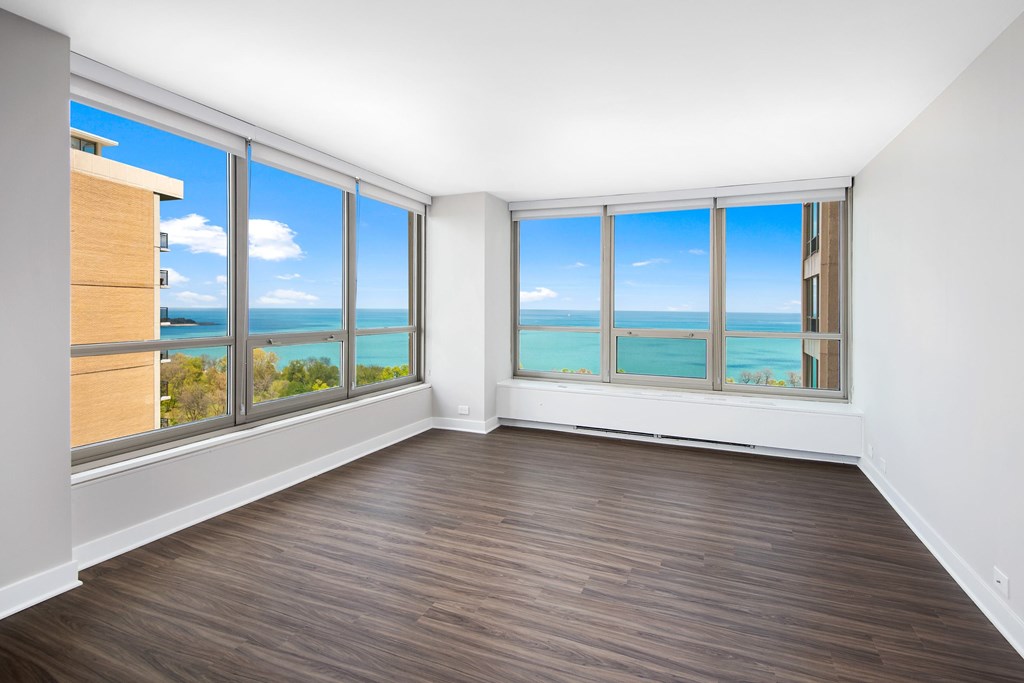 A room with a view of the ocean through large windows.