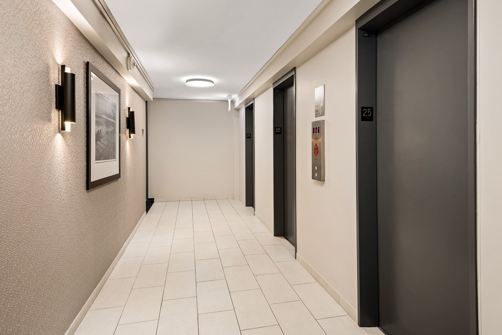 A hallway with a black door on the right and a white door on the left.