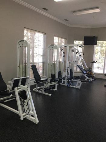 a gym with a lot of exercise equipment in it at Remington Apartment Homes, Romeoville, IL