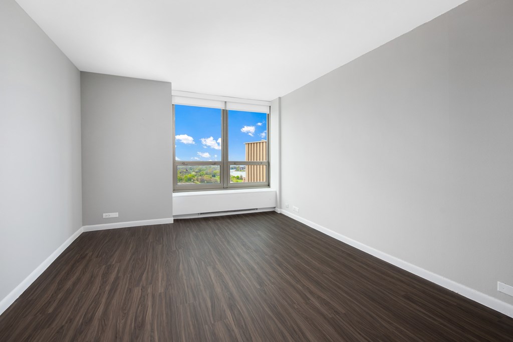 A room with a window overlooking a building.