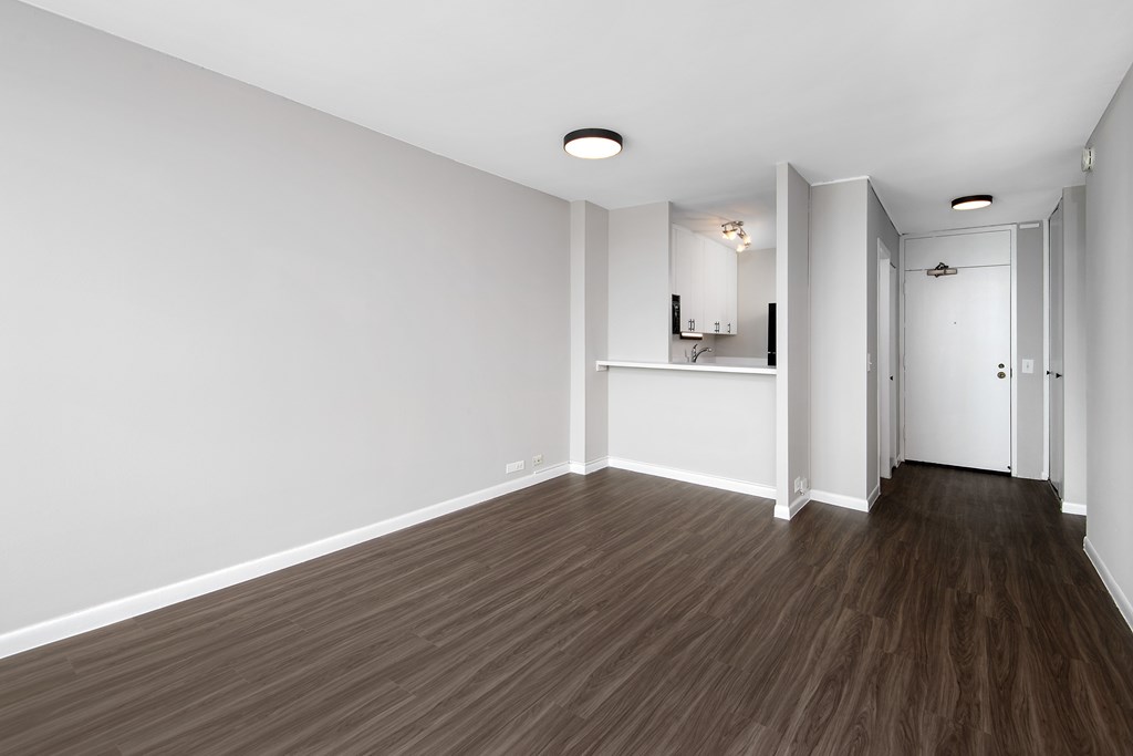 A room with wooden flooring and white walls.