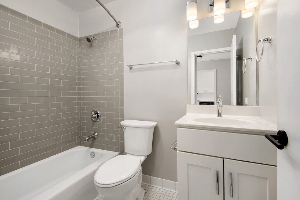 A white toilet sits next to a white sink in a bathroom.