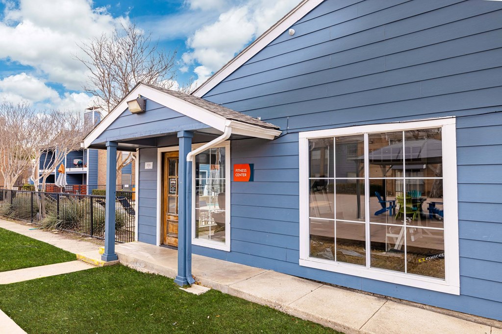 A blue building with a white door and windows.