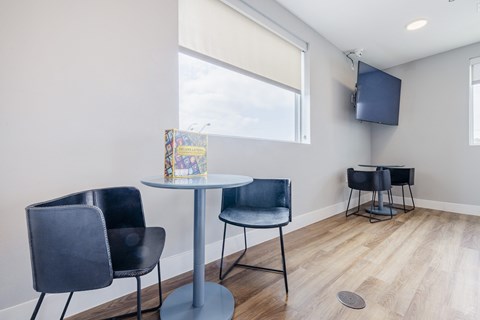 A room with a table, chairs and a television.