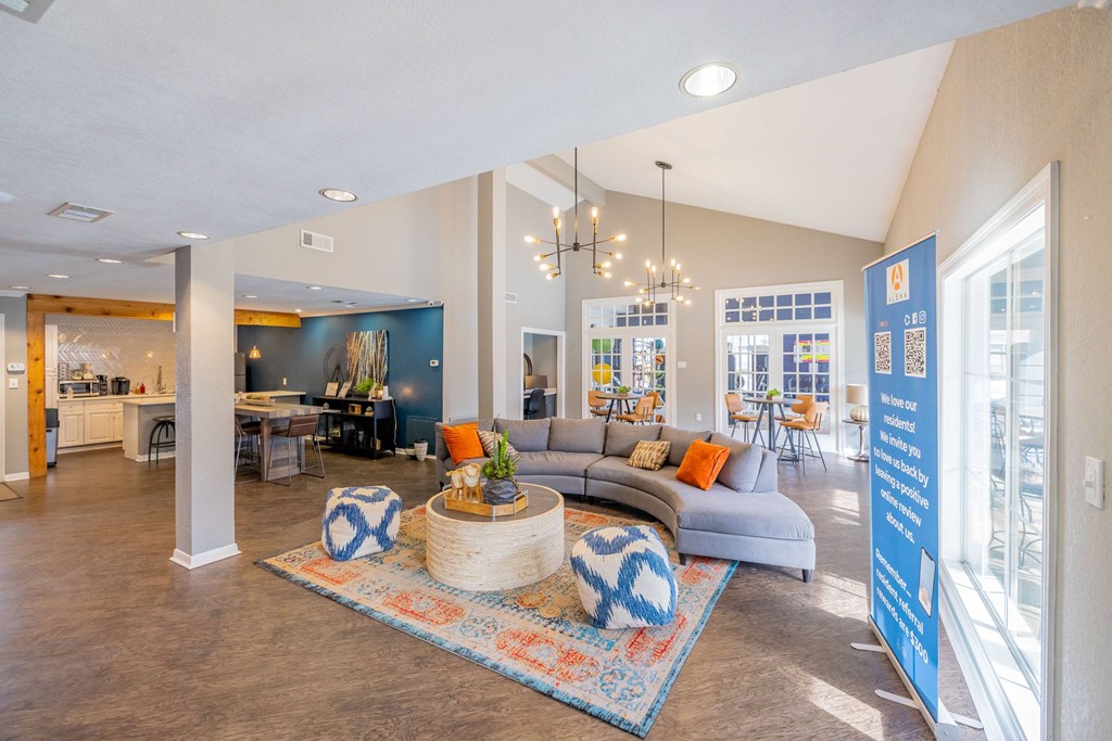 A living room with a grey couch and a rug.