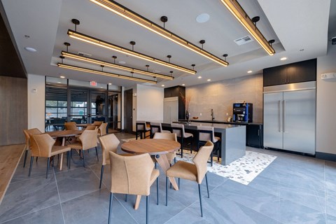 a dining room with tables and chairs and a kitchen