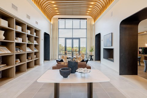 A modern living room with a long table and a fireplace.