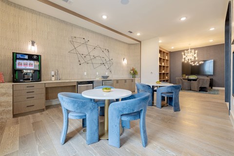 a dining room with blue chairs and a white table and a television